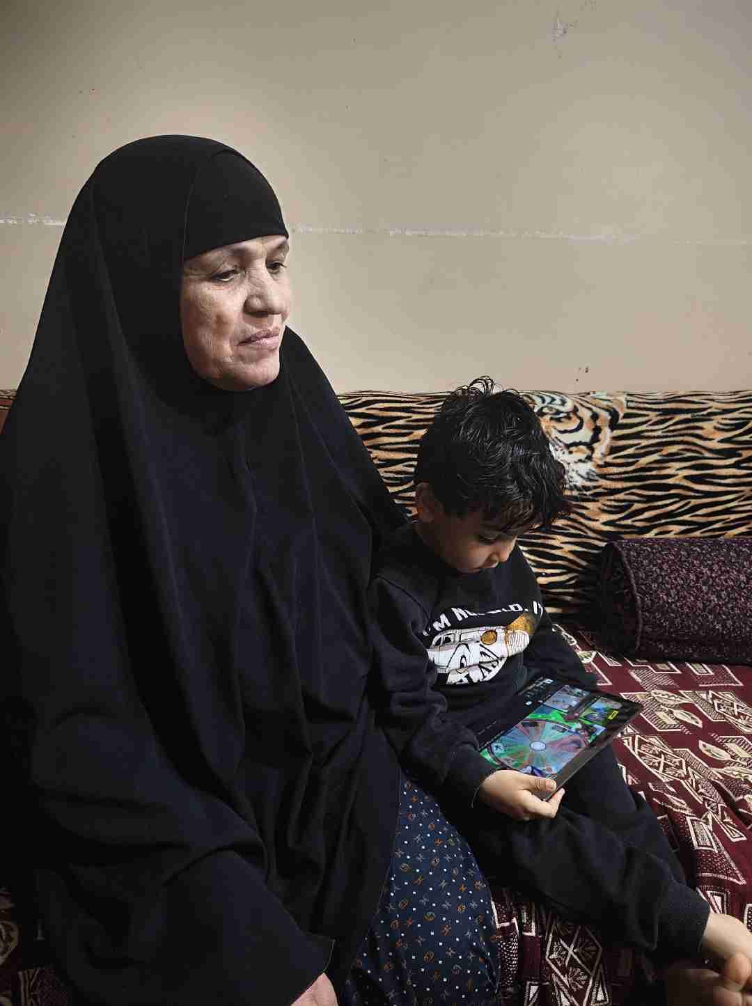 الطفل المصاب مع جدته الطفل المصاب مع جدته
