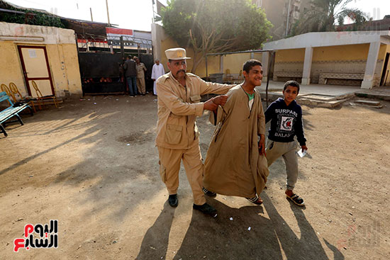 شرطى يساعد خمواطنا فى انتخابات البرلمان (2)