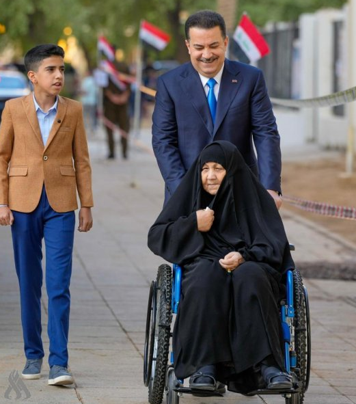 السوداني يصطحب والدته على كرسي متحرك