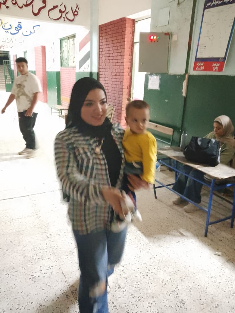 أمراة تحمل طفلها خلال التصويت