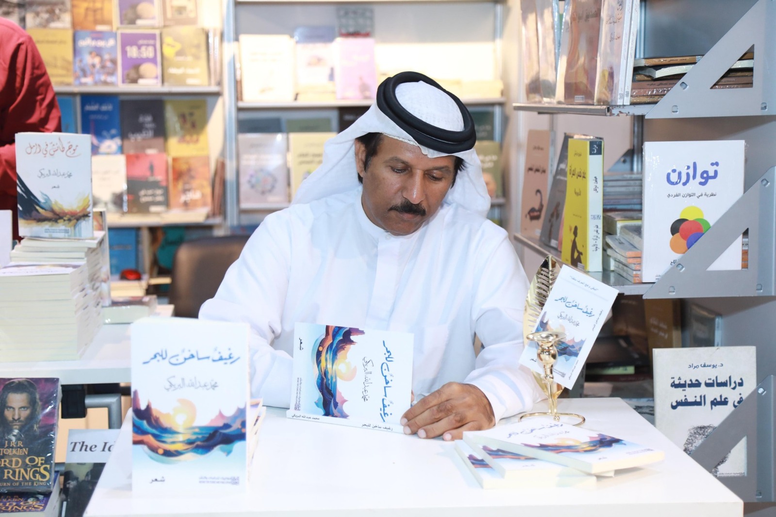 الشاعر محمد البريكى خلال توقيع ديوانه