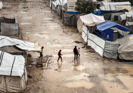 لهوى الأطفال وسط الخيام مع سقوط الأمطار