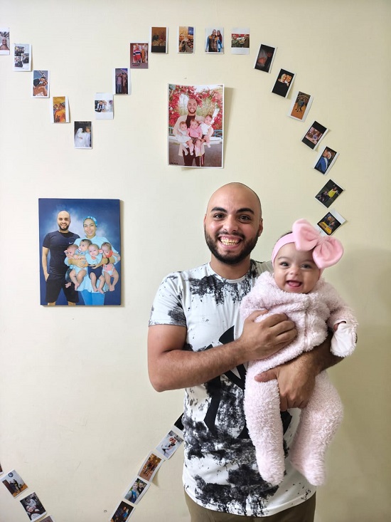 مؤمن يحمل طفلته