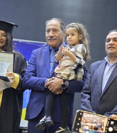 دكتور يحمل ابنة طالبة أثناء حفل التخرج