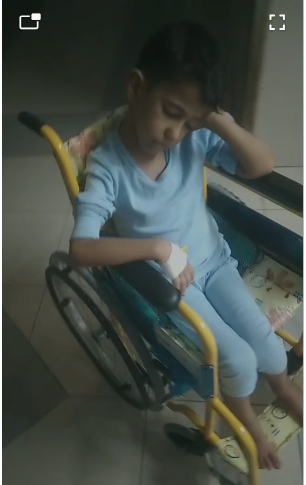 الطفل يامن أبو هلال على كرسى متحرك