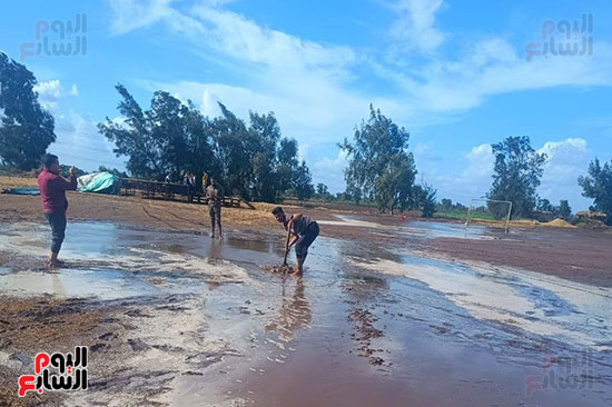 شباب القرية ينزحون المياه من الملعب