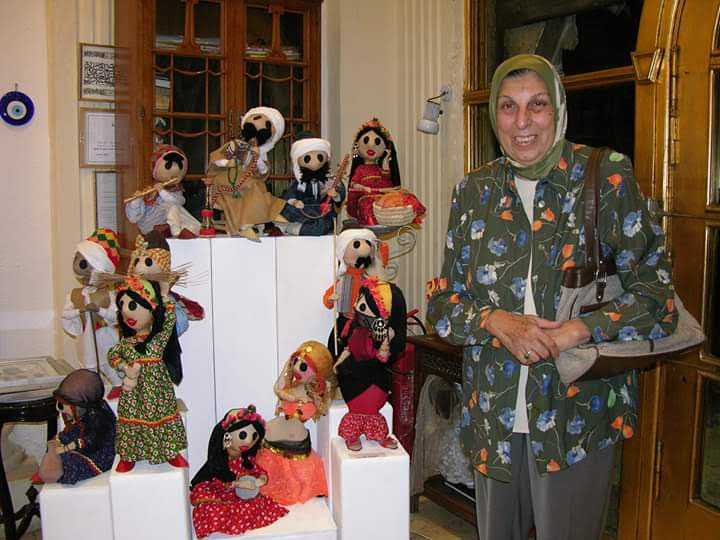 الفنانة نادية حسن بجانب تصميماتها