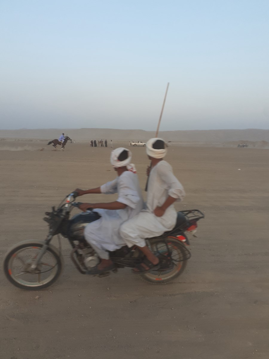 بدراجة نارية يتابعان سباق الخيول