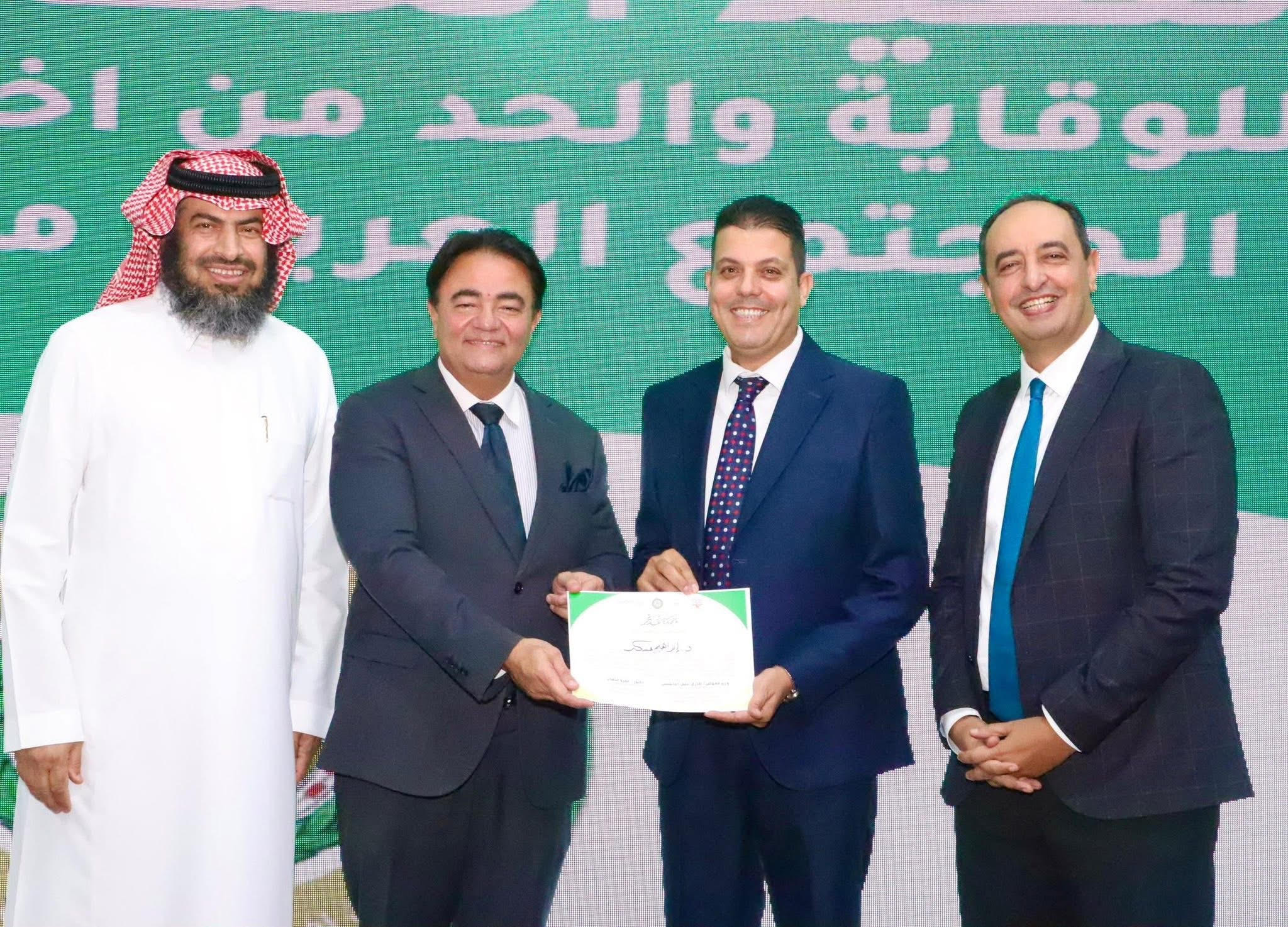 الدكتور إبراهيم عسكر يتسلم شهادة التكريم بحضور الدكتور عمرو عثمان والوزير المفوض طارق النابولسى