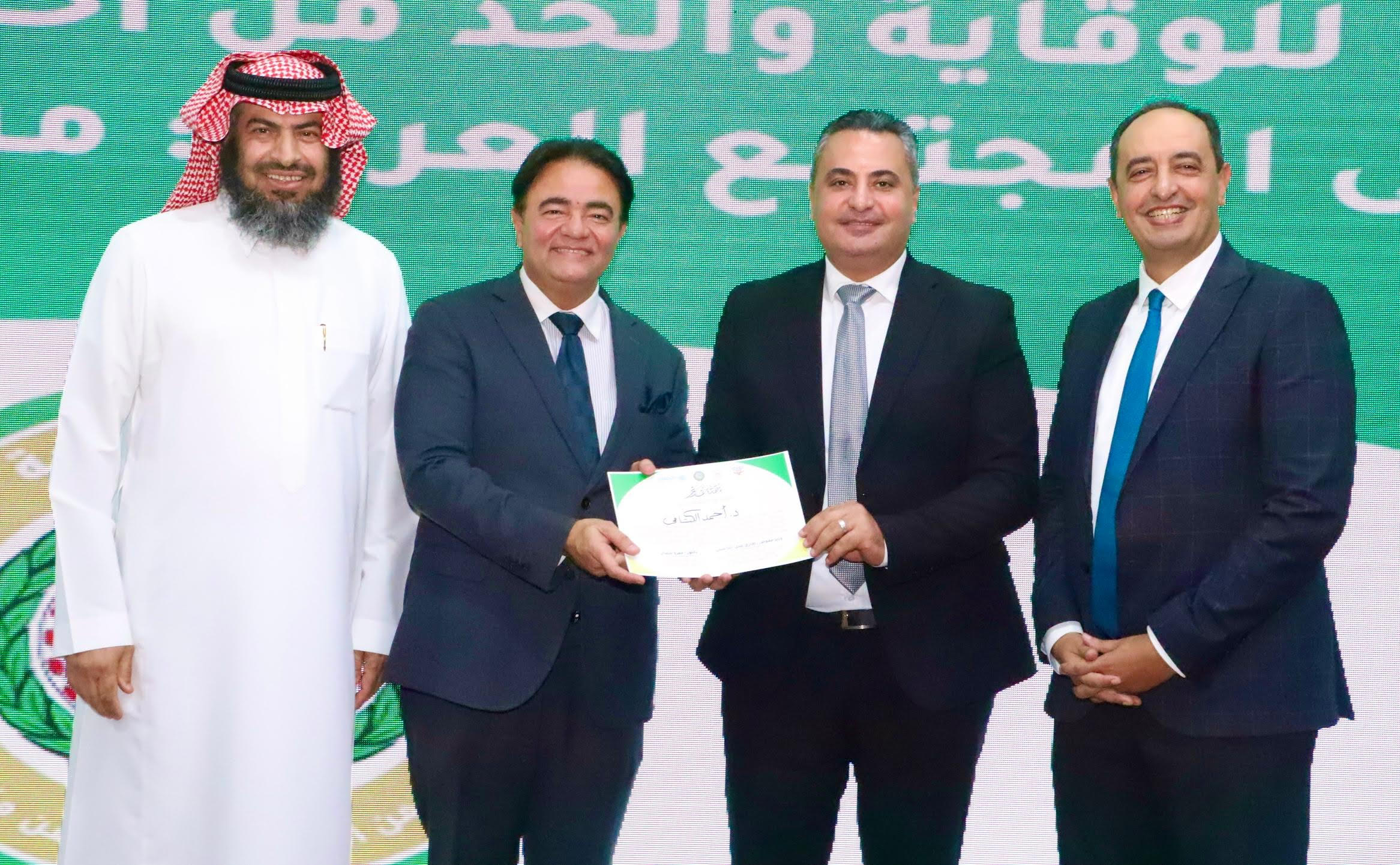 الدكتور أحمد الكتامى يتسلم شهادة التكريم بحضور الدكتور عمرو عثمان والوزير المفوض طارق النابولسى