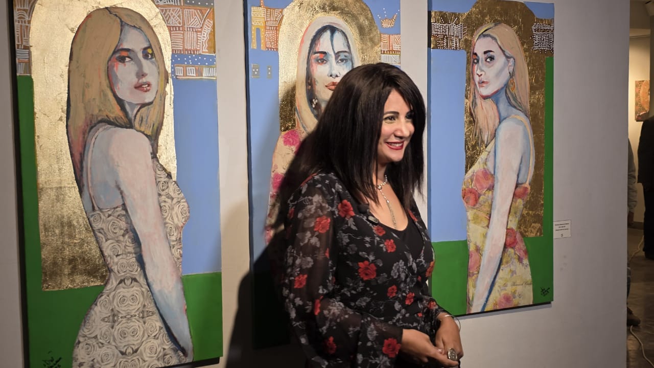 الفنانة شيماء رحيم بجانب لوحاتها