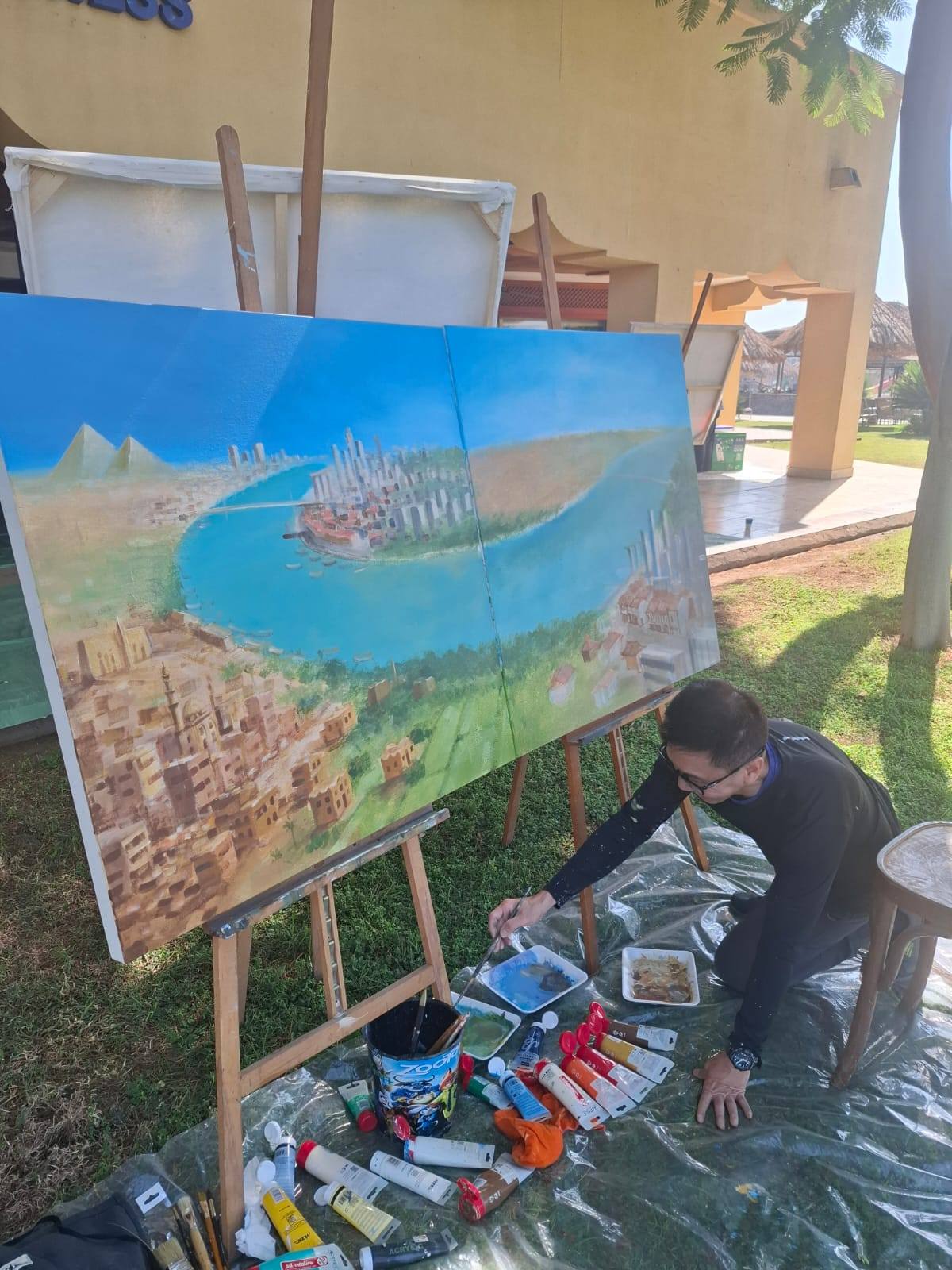 فنان صيني خلال رسم إحدي لوحاته بالملتقى فى الأقصر