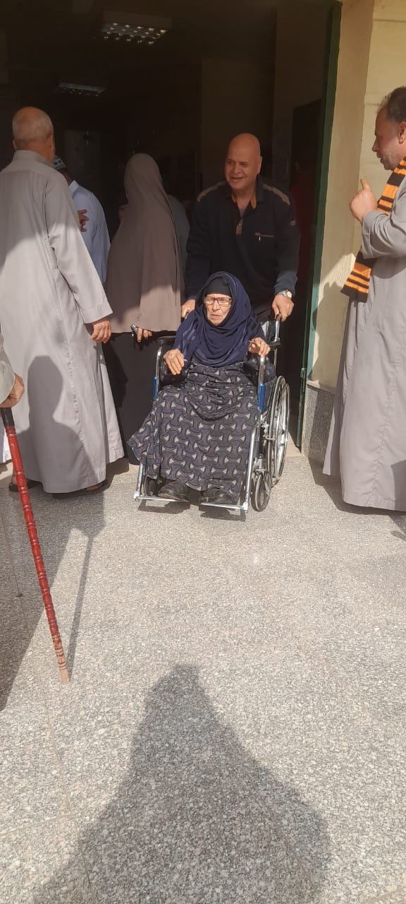 سيدة مسنة تدلي بصوتها في فوه