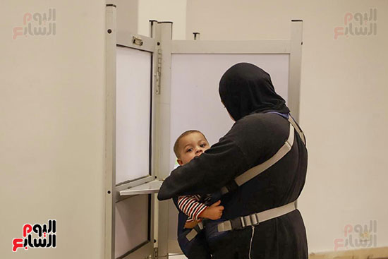 سيدة تحمل طفلها الرضيع أثناء التصويت (7)