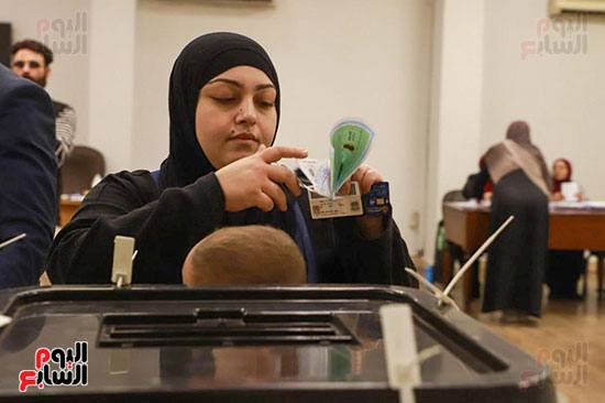 سيدة تحمل طفلها الرضيع أثناء التصويت (4)