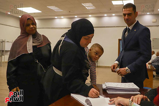 سيدة تحمل طفلها الرضيع أثناء التصويت (1)