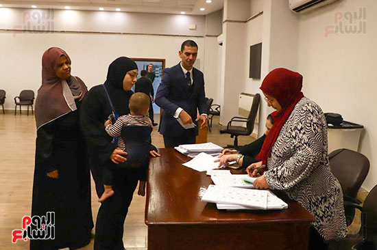 سيدة تحمل طفلها الرضيع أثناء التصويت (2)