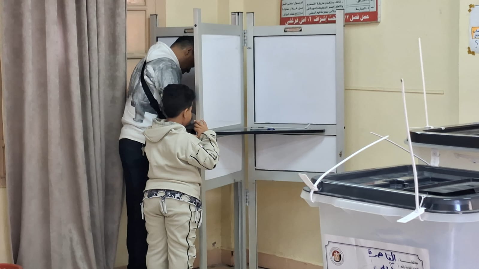  أب يصطحب نجله ليشهد معه لحظة التصويت