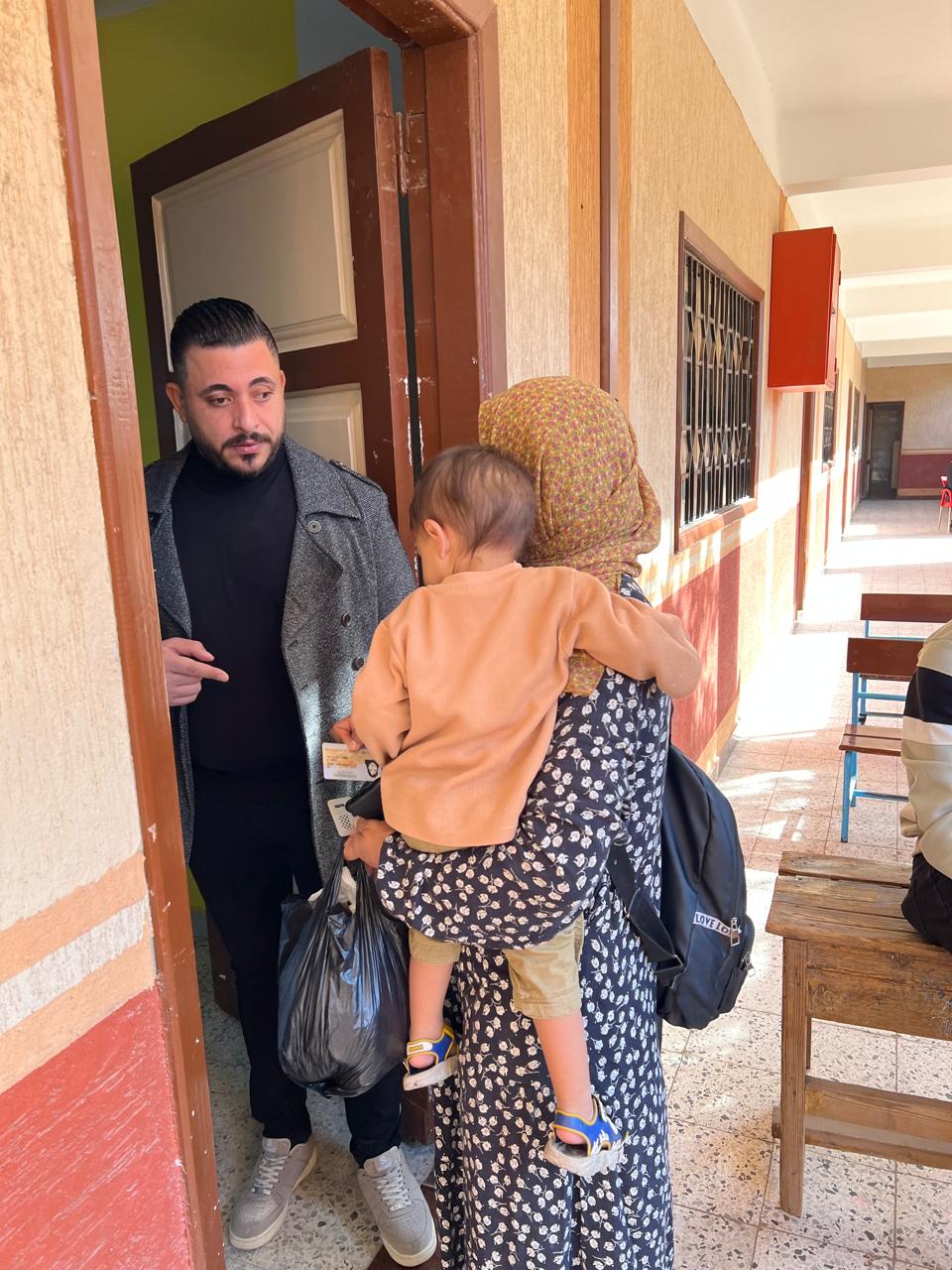 سيدة تصطحب طفلها اثناء التصويت سيدة تصطحب طفلها اثناء التصويت