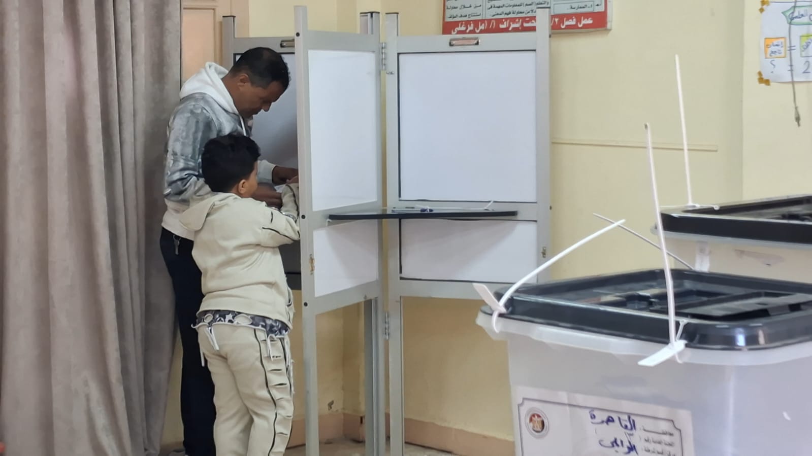  أب يصطحب نجله ليشهد معه لحظة التصويت فى انتخابات النواب