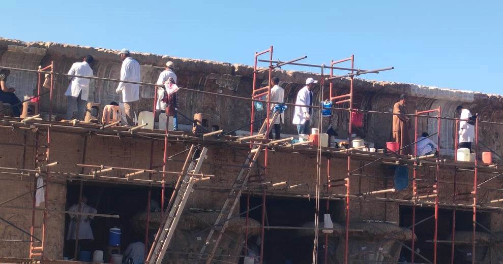 خلية نحل من الفنيين والاثريين يرممون واجهة معبد خنوم التاريخى