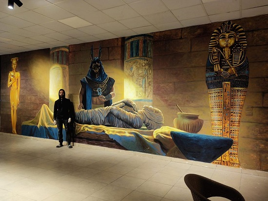 الفنان محمود فتوح بجانب لوحاته