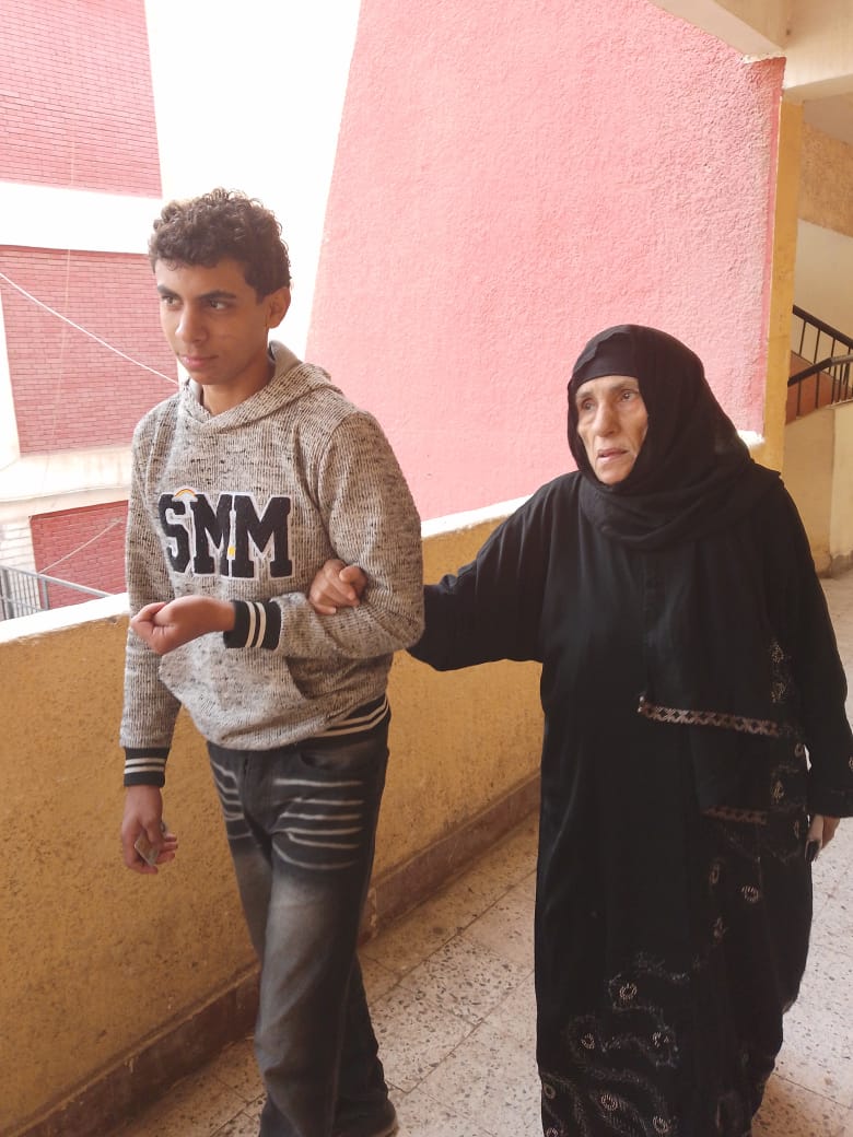 سيدة مسنة تتكئ على حفيدها للتصويت سيدة مسنة تتكئ على حفيدها للتصويت