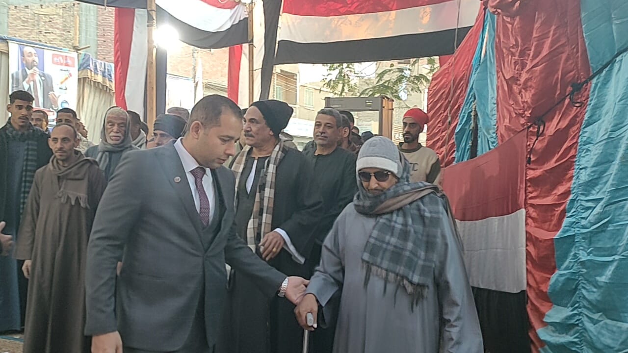 ضابط يستقبل مسن من على باب اللجنة ضابط يستقبل مسن من على باب اللجنة