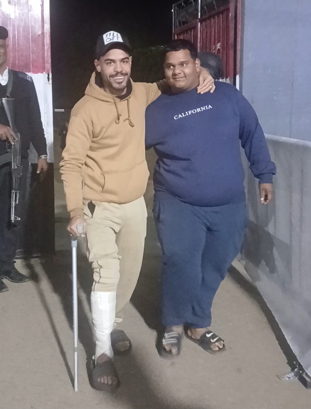 شاب مصاب بكسر يتعكز على صديقه شاب مصاب بكسر يتعكز على صديقه