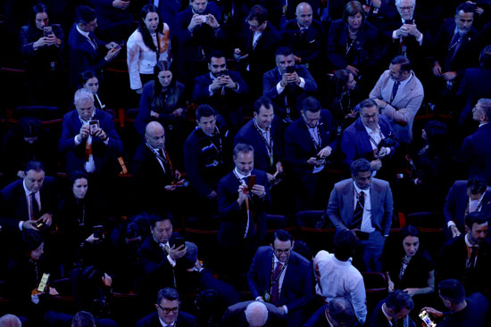 الحضور يلتقطون صورًا بهواتفهم قبل إجراء قرعة كأس العالم