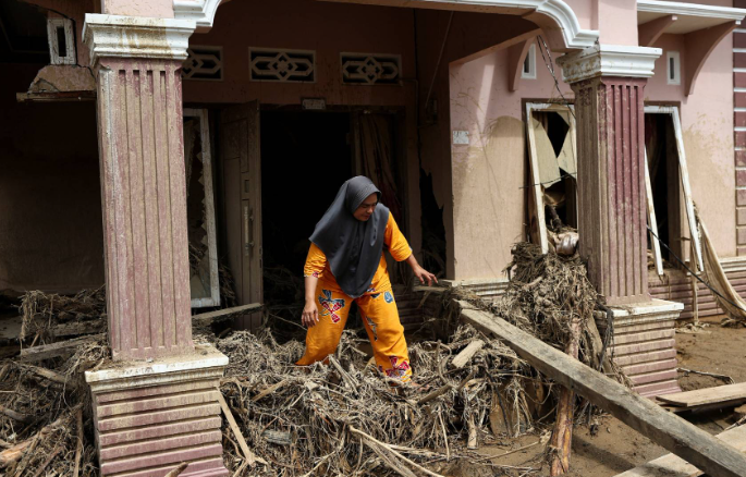 سيدة وسط منزلها المدمر