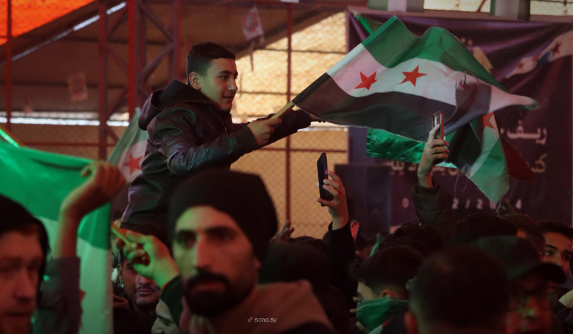 شاب يرفع العلم السوري