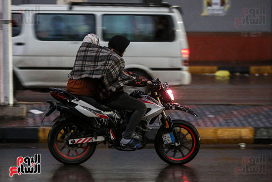 مواطن ووالدته على دراجة نارية وقت المطر مواطن ووالدته على دراجة نارية وقت المطر