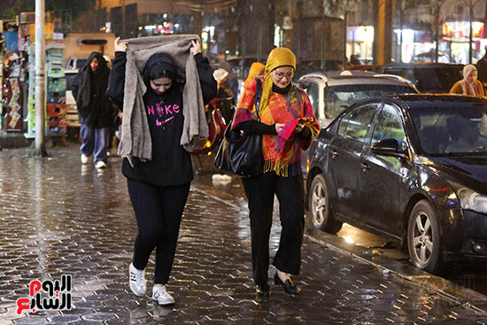 فتيات يغطين رؤسهن أثناء المطر فتيات يغطين رؤسهن أثناء المطر