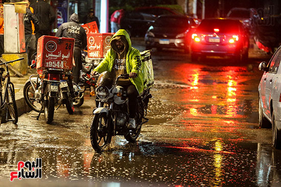 عامل دليفرى يقود دراجته تحت المطر عامل دليفرى يقود دراجته تحت المطر