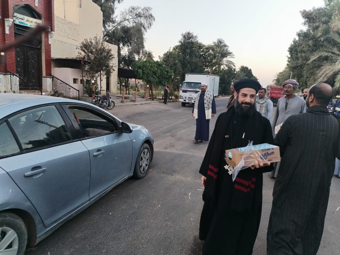 قمص يشارك  في إفطار صائمين على الطريق بقرية شنهور في قنا