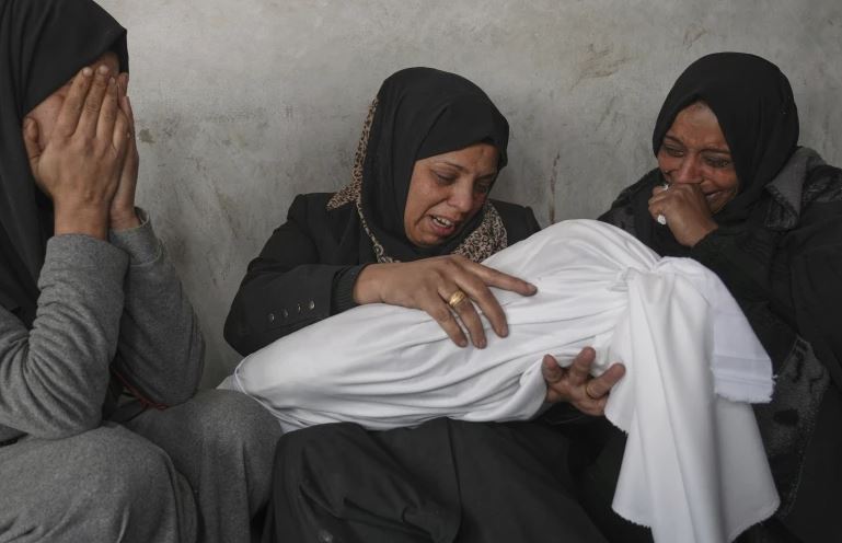 ام تحمل جثمان طفل شهيد