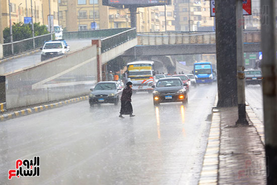 سيدة تعبر الطريق وسط الأمطار سيدة تعبر الطريق وسط الأمطار