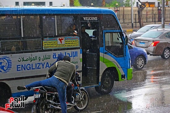 مواطن يساعد أحد المارة فى الإيصال للأتوبيس