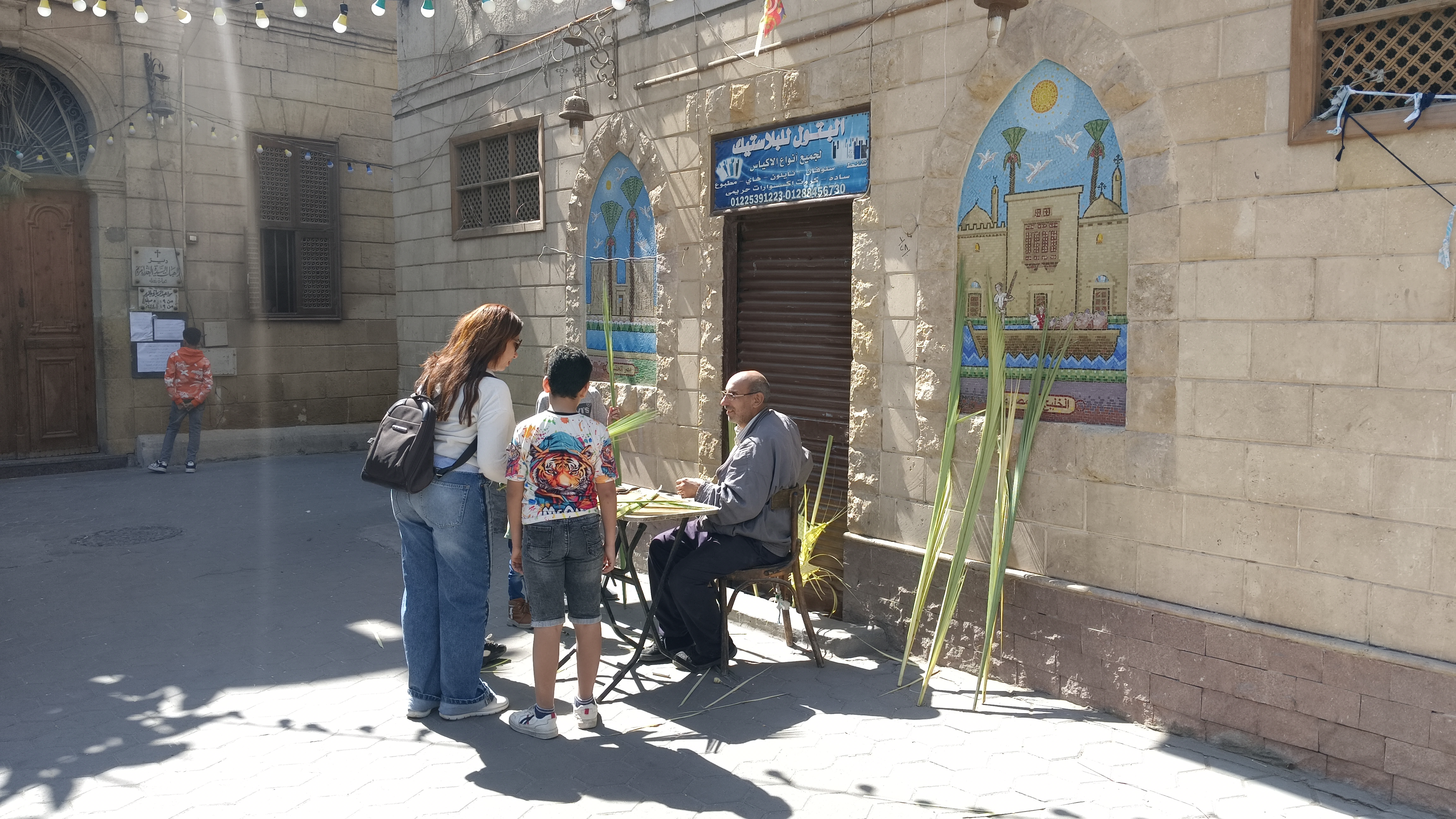 عرض أشكال متنوعة من السعف وأغصان الزيتون أمام الكنيسة عرض أشكال متنوعة من السعف وأغصان الزيتون أمام الكنيسة