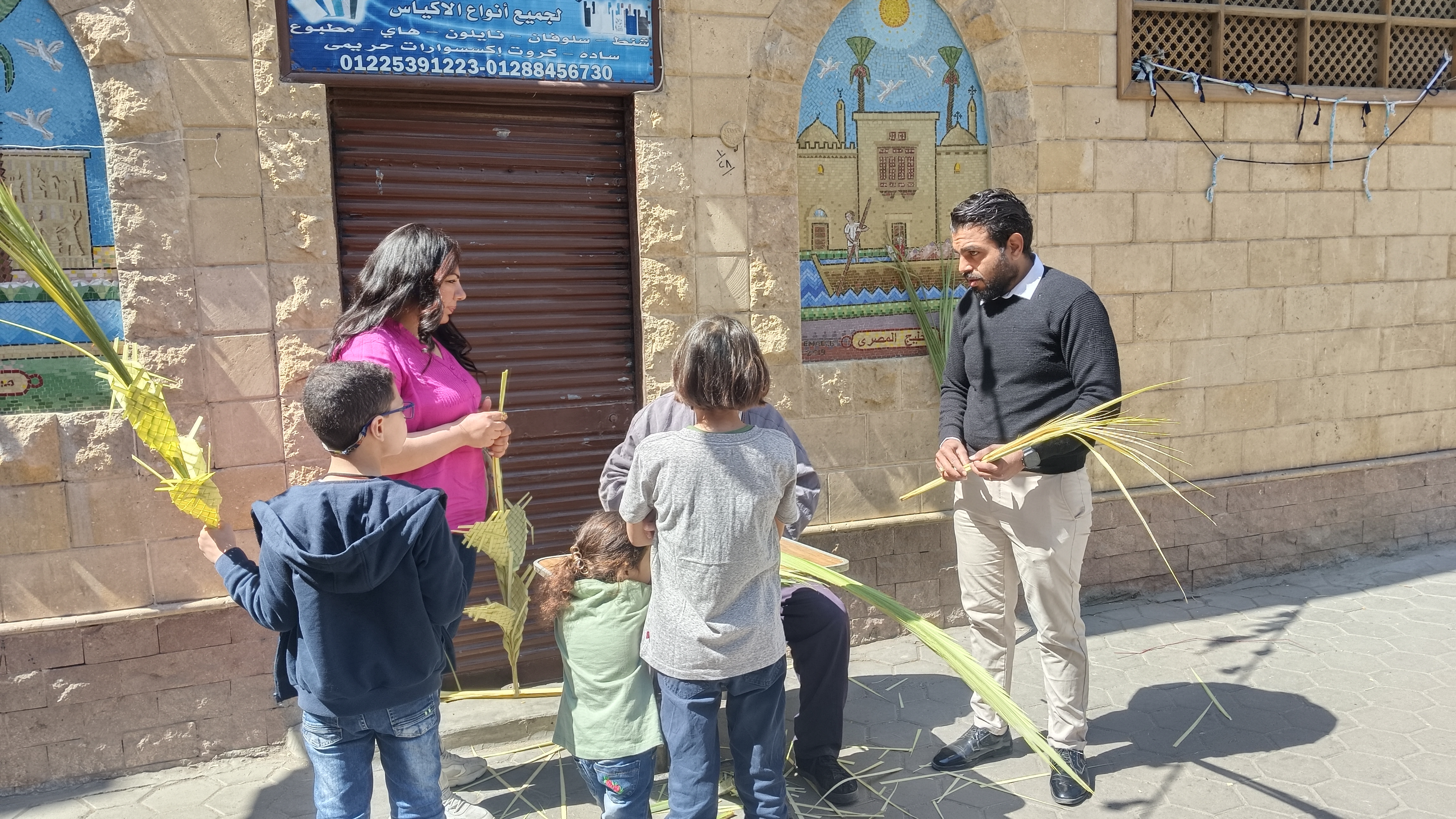 عرض أشكال متنوعة من السعف وأغصان الزيتون أمام الكنيسة عرض أشكال متنوعة من السعف وأغصان الزيتون أمام الكنيسة