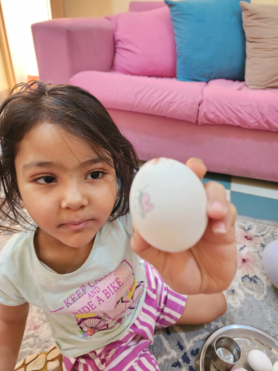 طفلة ترسم فراشة على البيض فى شم النسيم