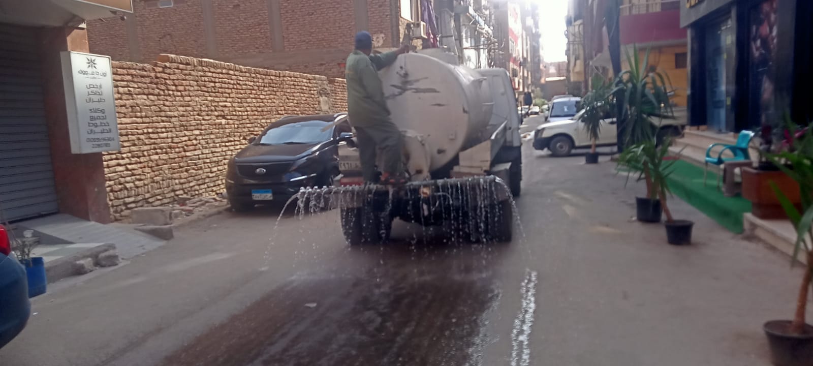 رش شارع الجوازات بعد رفع مخلفات عربات الحنطور