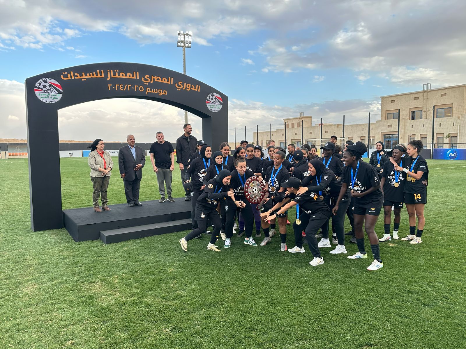 لاعبات مسار يحملن الدرع
