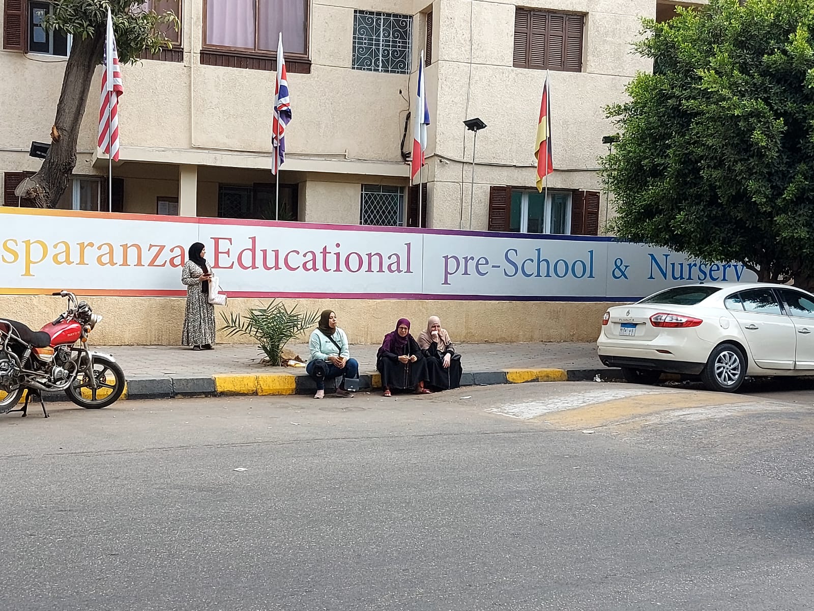 الأمهات ينتظرن أبنائهم على الرصيف