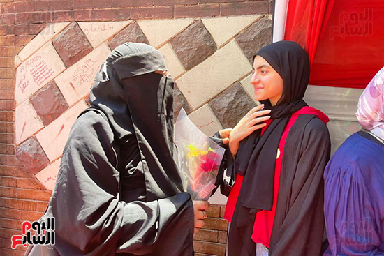 أم تستقبل ابنتها بالورود أمام لجنة الامتحان