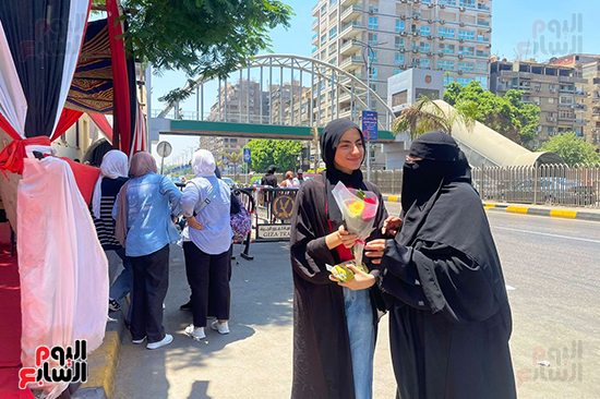 أم تستقبل ابنتها بالورود بعد أداء الامتحان (1)