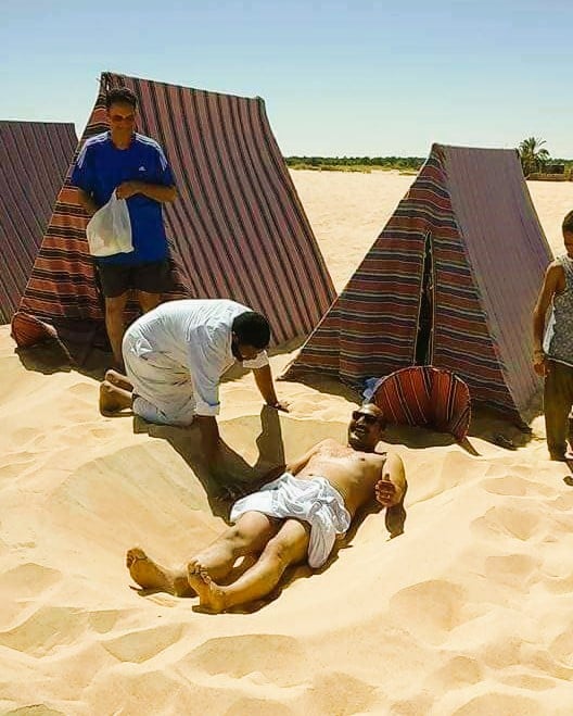 تجهيز احد المرضى لتغطية جسده بالرمال تجهيز احد المرضى لتغطية جسده بالرمال