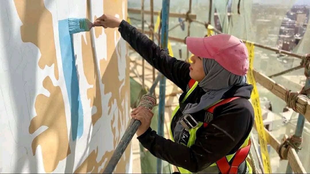 الفنانة مها جميل أثناء الرسم