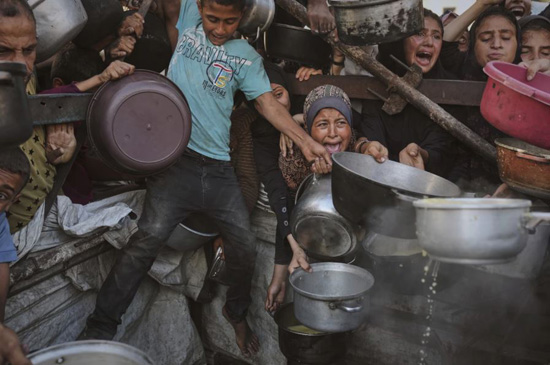 مدينة غزة، قطاع غزة (أسوشيتد برس) - سعى الفلسطينيون جاهدين للحصول على الطعام من مطبخ مجتمعي مكتظ يوم الاثنين في مدينة غزة، شمال قطاع غزة. وقد أدت حرب إ (4)